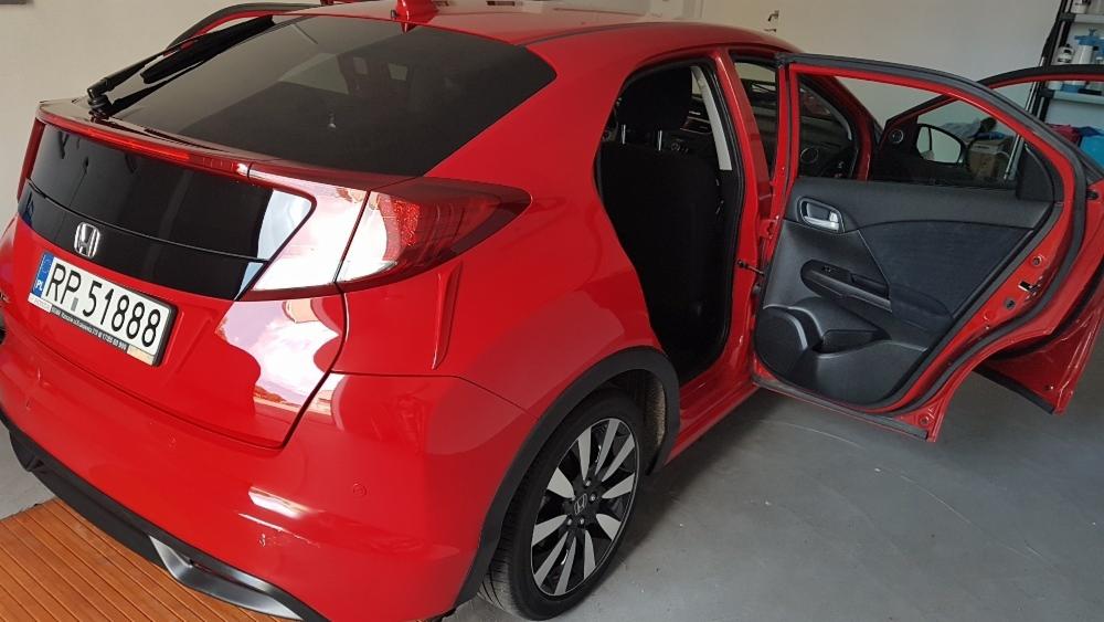 Czerwony samochód Honda Civic z otwartymi tylnymi drzwiami, widoczny numer rejestracyjny RP 51888.