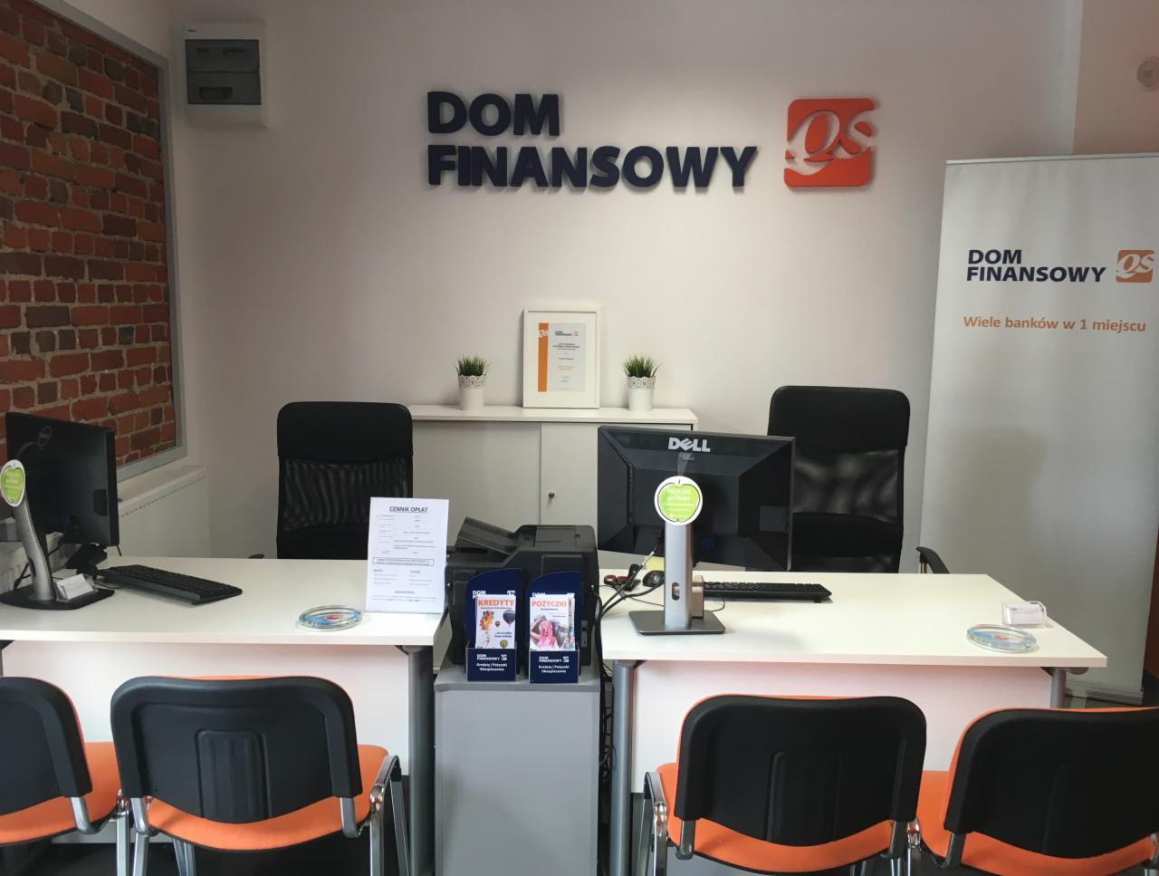 Biuro Domu Finansowego z dwoma stanowiskami pracy, monitorami Dell, krzesłami z pomarańczowymi oparciami, ścianą z cegły i logo firmy na ścianie oraz bannerem reklamowym.