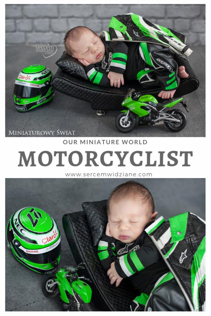 Śpiący noworodek ubrany w strój motocyklisty leży na małej, pikowanej sofie obok miniaturowego motocykla i kasku.