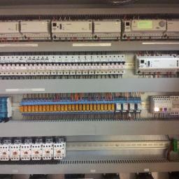 VENTI CONTROL Piotr Spławski - Szara szafa sterownicza z modułami Siemens, bezpiecznikami, przekaźnikami i okablowaniem, widoczne liczne złącza śrubowe.