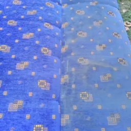 Połowa niebieskiej kanapy z geometrycznym wzorem jest wyraźnie czystsza od drugiej, brudniejszej połowy, co demonstruje efekt czyszczenia tapicerki.
