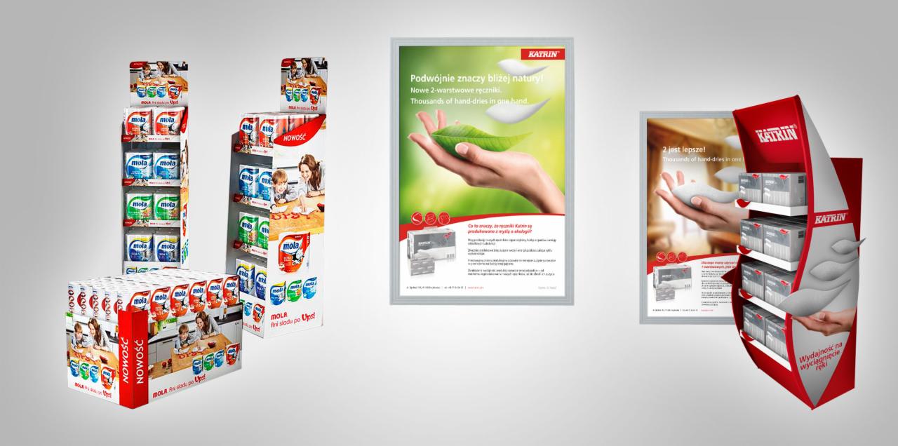 Ekspozycja materiałów reklamowych, w tym stojaków z produktami i plakatów w ramkach, prezentująca artykuły higieniczne marek Mola i Katrin.