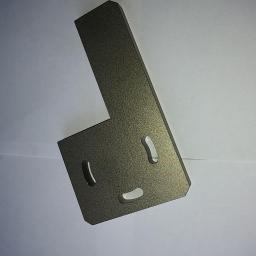 KG Technology - Metalowy kątownik z trzema owalnymi otworami, wykończony szorstką, ciemnoszarą powłoką, leżący na białym tle.