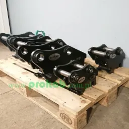 Czarne, metalowe szybkozłącza do maszyn budowlanych marki Prokab ułożone na drewnianej palecie EPAL w szarym pomieszczeniu.