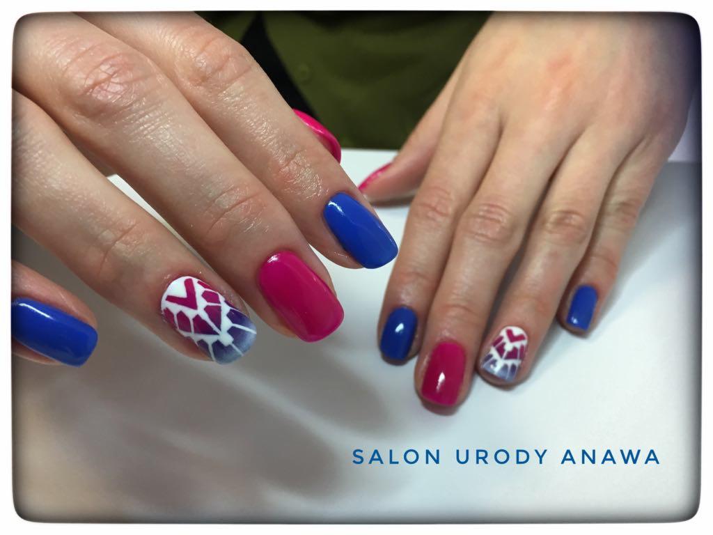 Dłonie z manicure hybrydowym w kolorach fuksji i kobaltu, jeden paznokieć z geometrycznym wzorem ombre w odcieniach fioletu i bieli, widoczne logo salonu urody.