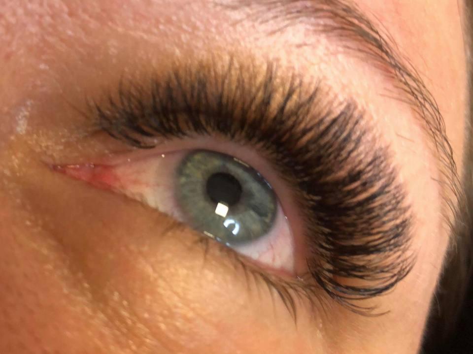 Zbliżenie na oko z gęstymi, czarnymi sztucznymi rzęsami w Kuklówka Radziejowicka, z delikatnym odblaskiem światła na tęczówce.