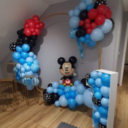 ANIMATOR Izabela Zbiega - Dekoracja balonowa na pierwsze urodziny z motywem Myszki Miki, składająca się z łuku z balonów w kolorach niebieskim, czerwonym i czarnym, oraz cyfry '1' wypełnionej balonami.