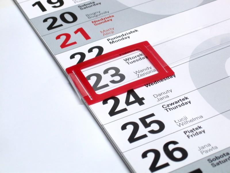 Fragment kalendarza ściennego z zaznaczonym dniem 23, widoczne nazwy dni tygodnia i imiona.
