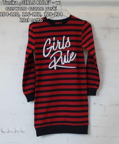 Tunika dziewczęca w czerwono-czarne paski z napisem 'Girls Rule', prezentowana na wieszaku na tle ściany.