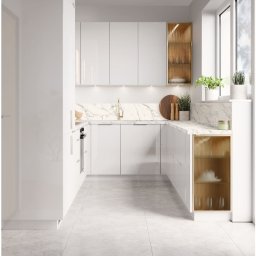 MJM MEBLE Marcin Miszczyk - Biała, nowoczesna kuchnia z marmurowym blatem i złotymi akcentami w postaci ryflowanych frontów szafek. Minimalistyczny design, jasne wnętrze, rośliny w oknie.