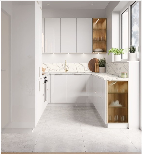 Biała, nowoczesna kuchnia z marmurowym blatem i złotymi akcentami w postaci ryflowanych frontów szafek. Minimalistyczny design, jasne wnętrze, rośliny w oknie.