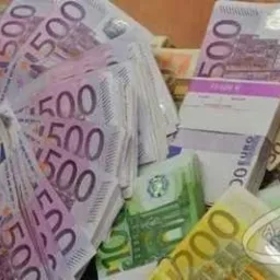 Stos banknotów euro o nominałach 500 i 200 w dłoni, z widocznymi banderolami na niektórych plikach banknotów.