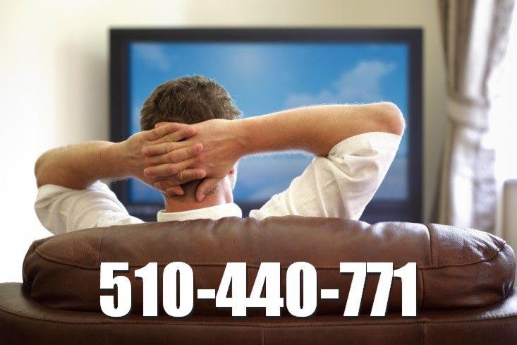 Mężczyzna siedzi na skórzanej kanapie, relaksując się przed telewizorem wyświetlającym błękitne niebo, z numerem telefonu nałożonym na obraz.