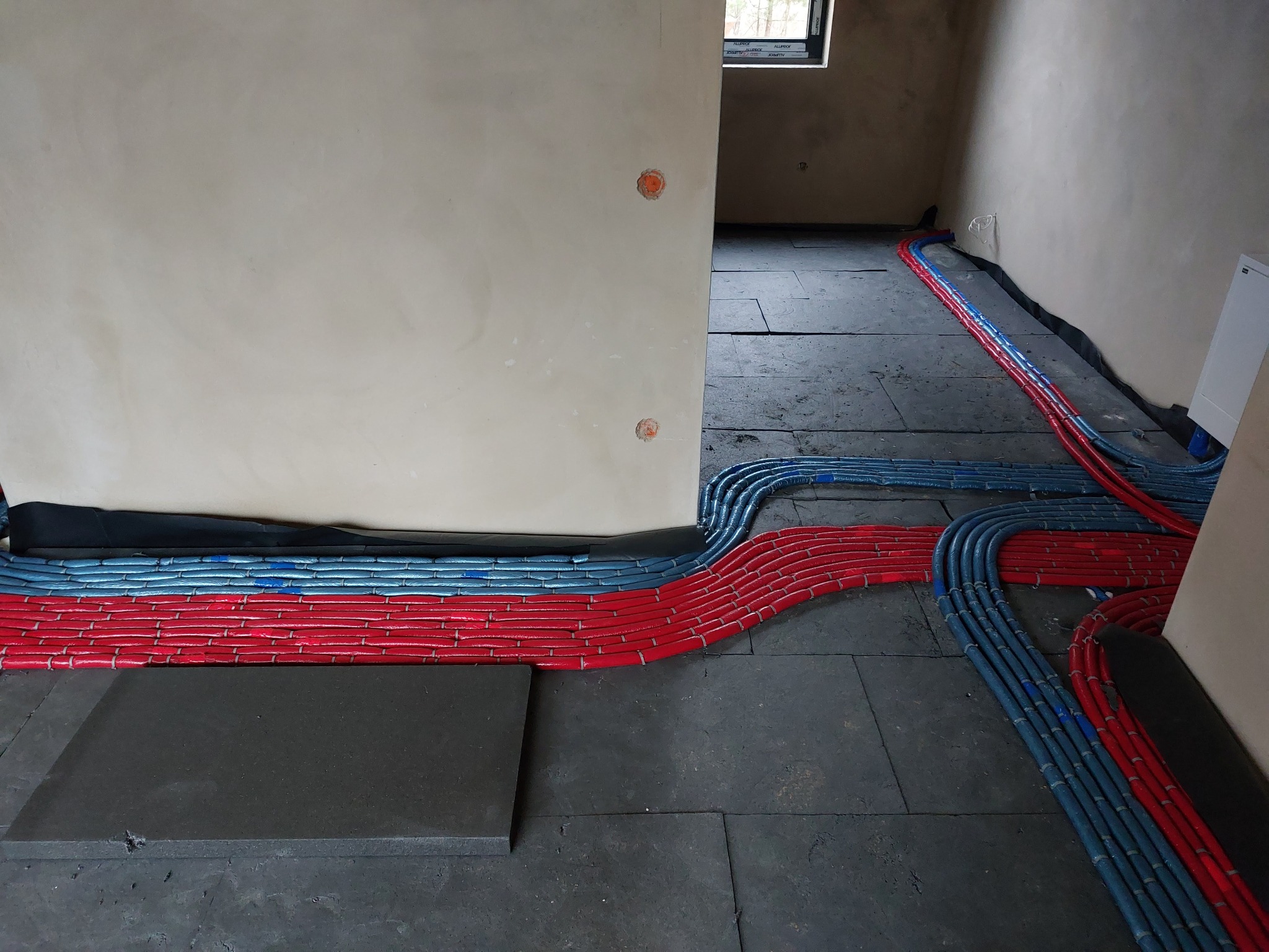 Woda użytkowa w systemie rozdzielaczowym na pierwszej warstwie styropianu.