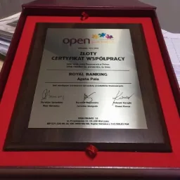 Złoty certyfikat współpracy Open Partners w bordowej ramce, przyznany firmie Royal Banking za sprzedaż produktów finansowych, z podpisami dyrektorów.