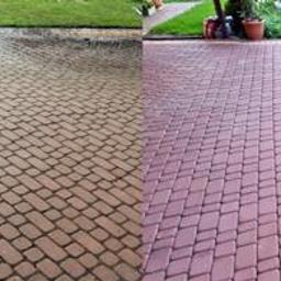 PerfectFloor - Częściowo wyczyszczona kostka brukowa na podjeździe, widoczna różnica w kolorze i czystości między umytą a nieumytą powierzchnią, trawnik w tle.