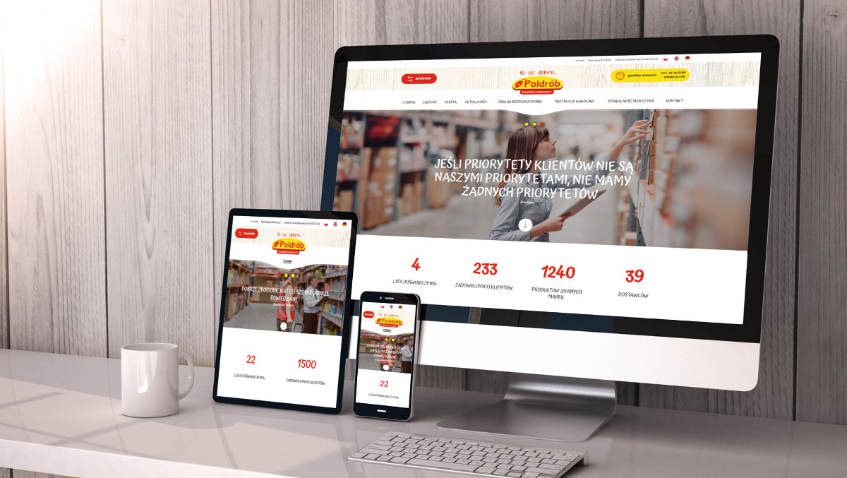 Responsywna prezentacja strony internetowej Poldrob na monitorze, tablecie i smartfonie, widok z boku na biurku z białą klawiaturą i kubkiem.