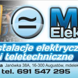 Panel elektryczny z podłączonym multimetrem cyfrowym wskazującym napięcie, logo firmy MD Elektro i dane kontaktowe.