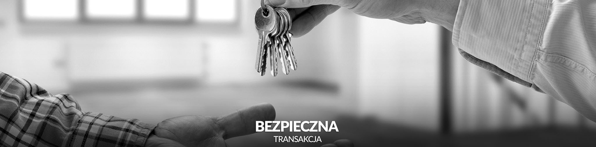 Czarno-białe zdjęcie przedstawia wymianę kluczy między dwiema rękami, symbolizującą bezpieczną transakcję nieruchomości.