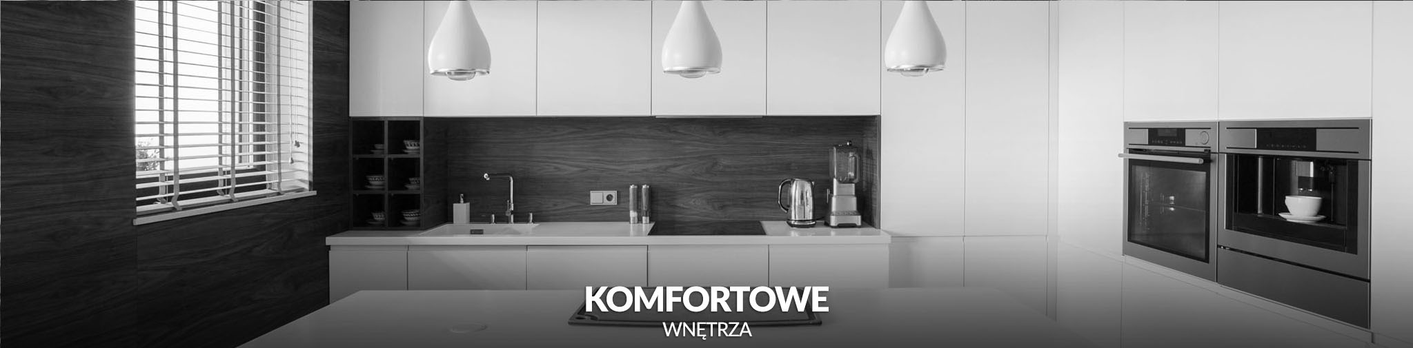 Nowoczesna, minimalistyczna kuchnia w odcieniach bieli i szarości z drewnianymi akcentami, oświetlona trzema wiszącymi lampami w kształcie kropli, z zabudowanym ekspresem do kawy z filiżanką...