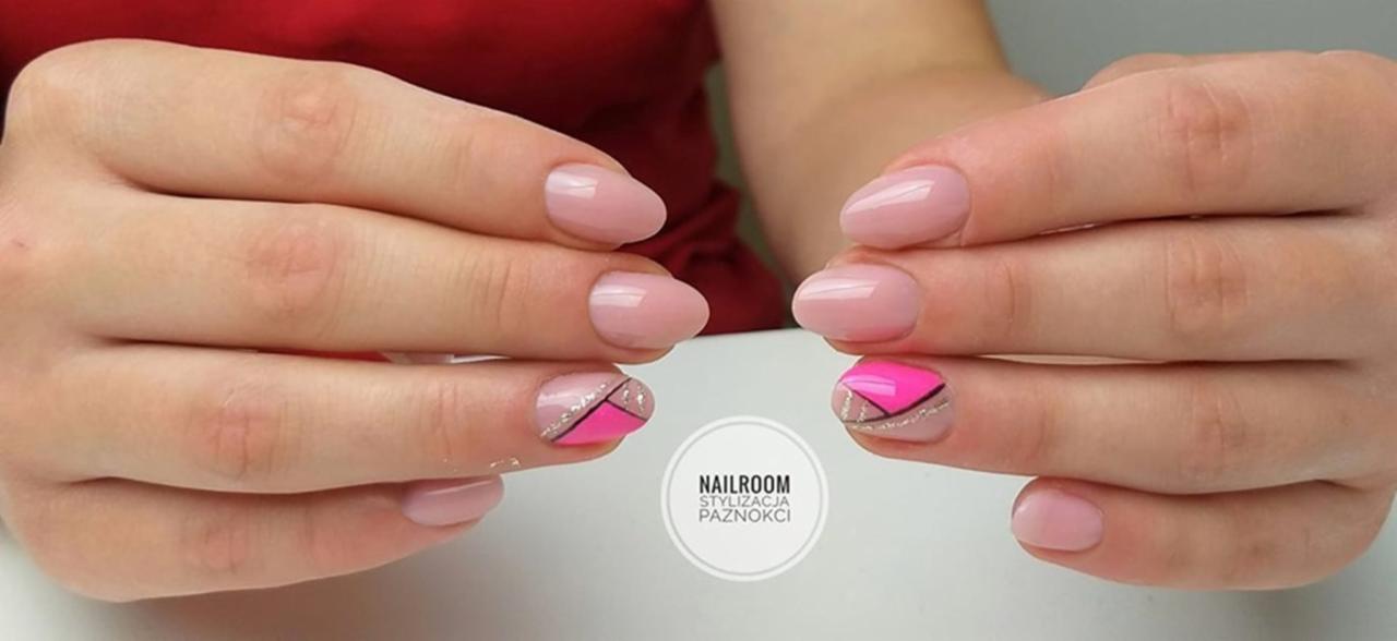Dłonie z delikatnym, różowym manicure hybrydowym i akcentem geometrycznym w postaci różowego trójkąta oddzielonego srebrną linią brokatu na jednym z paznokci.