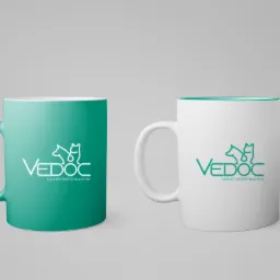 Dwa kubki: turkusowy i biały z turkusowym wnętrzem, oba z logo gabinetu weterynaryjnego Vedoc, ustawione na jasnoszarym tle.