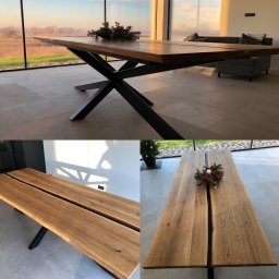 P.H.U. Ja-Ry Jacek Rycharski - Stół z blatem z dwóch desek dębowych, z czarną metalową podstawą w kształcie gwiazdy, w nowoczesnym wnętrzu z dużym oknem i widokiem na zewnątrz. Dekoracja świąteczna na blacie.