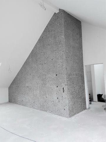 Ściana w pokoju na poddaszu w Opatowie wykończona płytami imitującymi kamień, widoczne puszki elektryczne.