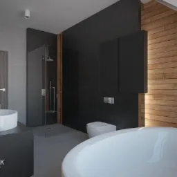 Nowoczesna łazienka w szarościach i drewnie: okrągła wanna, umywalka nablatowa, kabina prysznicowa typu walk-in, drewniana boazeria na skośnej ścianie poddasza.