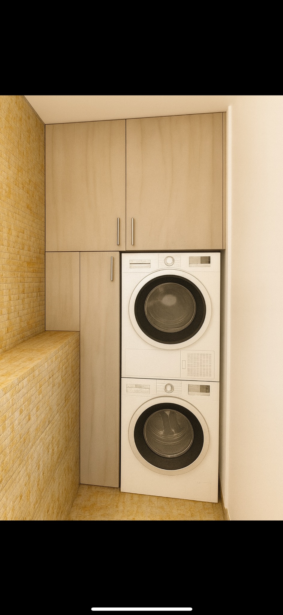 Zabudowa pralki i suszarki w łazience z beżowymi szafkami podwieszanymi i ścianą z cegieł w ciepłym odcieniu. Minimalistyczny design i funkcjonalne rozwiązanie do małych przestrzeni.