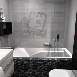 ImperMar Design - Nowoczesna łazienka w odcieniach szarości, czerni i czerwieni z wanną obudowaną mozaiką, podświetlanym lustrem, umywalką nablatową i wnęką z czerwonym tłem.