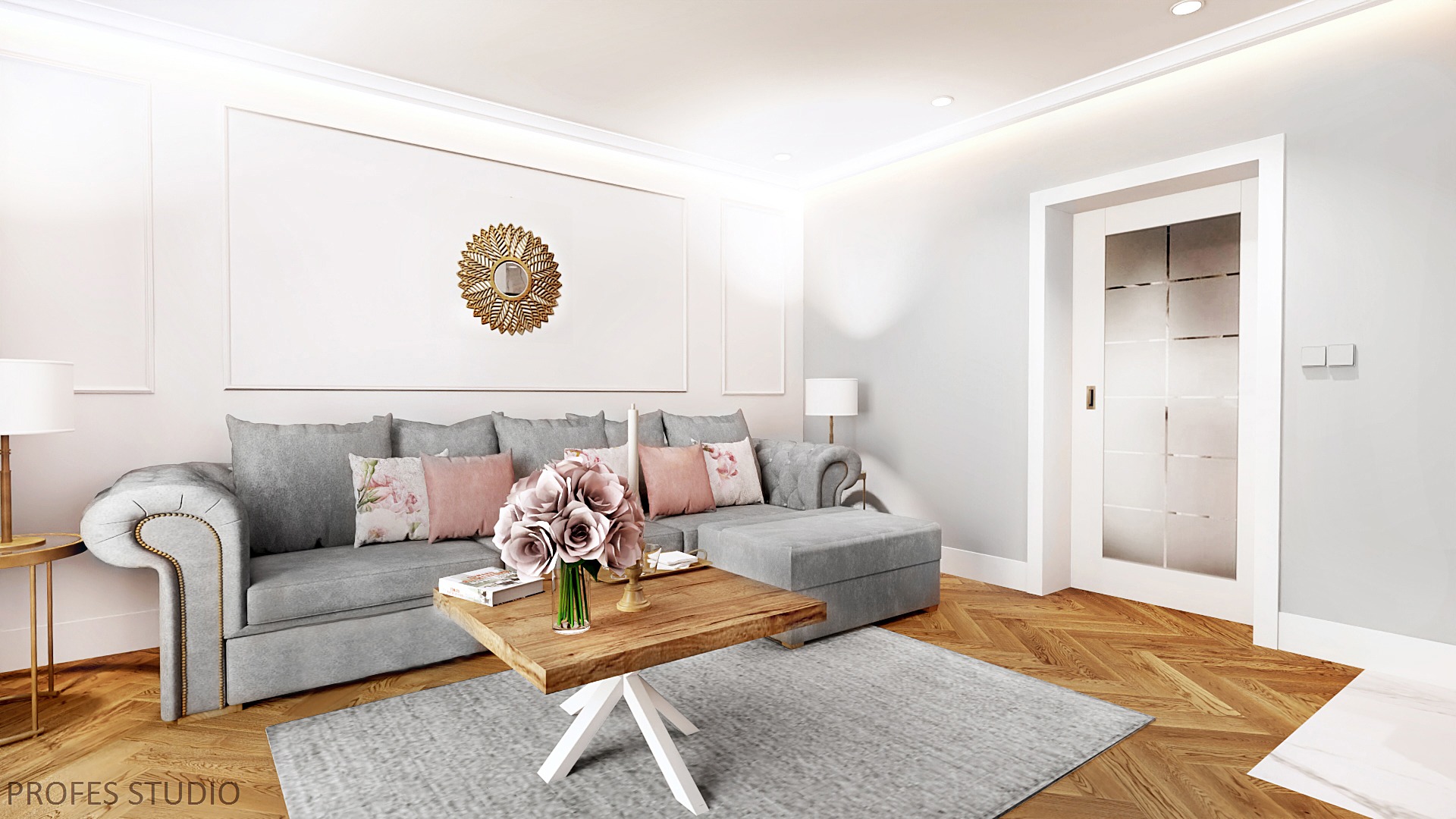 Salon w odcieniach szarości z drewnianą podłogą w jodełkę, szarą sofą z poduszkami w kwiaty i różu, drewnianym stolikiem kawowym z bukietem różowych róż i złotym lustrem nad sofą.