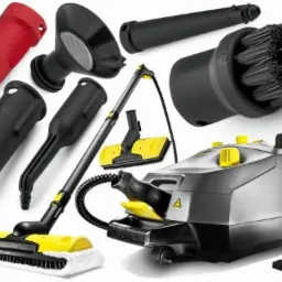 Zestaw akcesoriów do parowego urządzenia czyszczącego, zawierający dysze, szczotki i końcówki w kolorze czarnym, czerwonym i żółtym, ułożone wokół głównego urządzenia na białym tle.