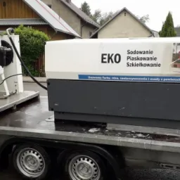 Mobilny zestaw do obróbki strumieniowo-ściernej na przyczepie, z widocznymi zbiornikami i kompresorem EKO, gotowy do transportu na miejsce realizacji usługi.