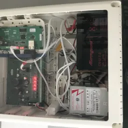 Wnętrze skrzynki z elektroniką systemu alarmowego, widoczne moduły Satel Integra i ETHM-1 Plus, akumulator Alarmguard, transformator Noratel, okablowanie i diody sygnalizacyjne w Wojkowicach.