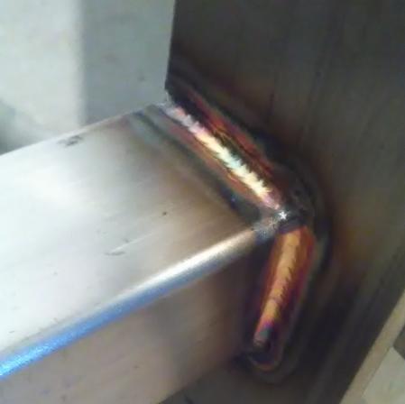 Spoina kątowa na metalowej konstrukcji, widoczne tęczowe przebarwienia termiczne, wykonana z dużą precyzją.