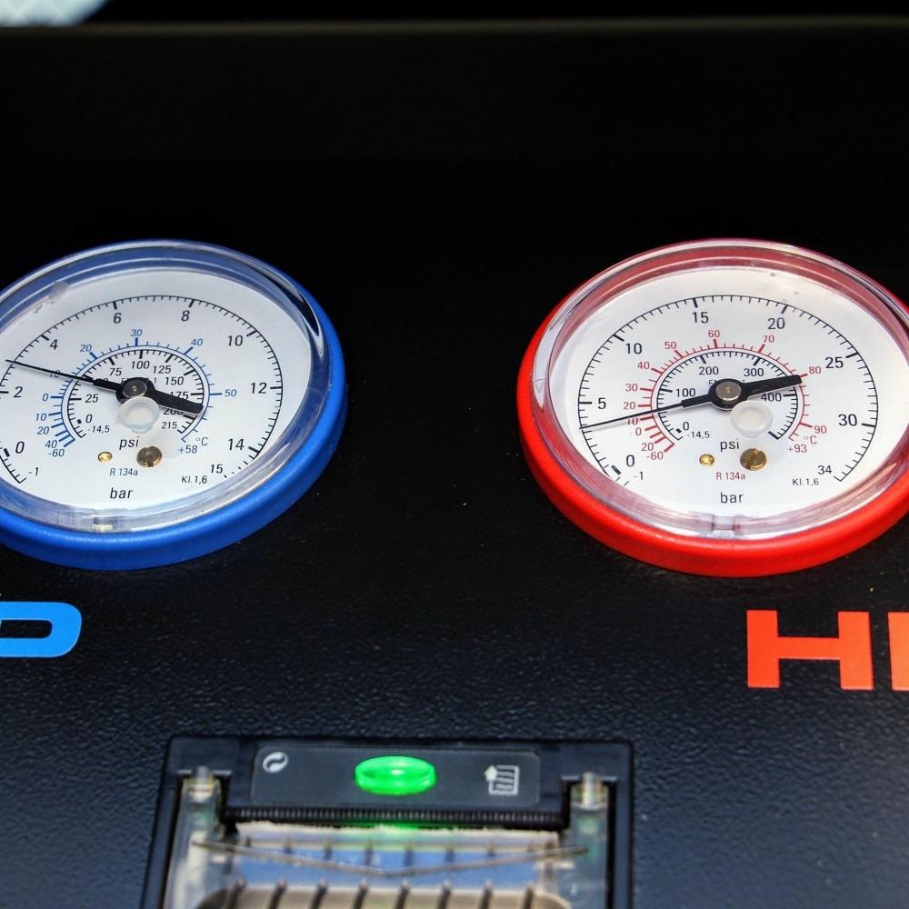 Manometry niskiego i wysokiego ciśnienia na maszynie do serwisowania układów chłodniczych z widocznym wskaźnikiem poziomu czynnika R134a.