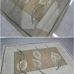 Dwu-częściowe ujęcie dywanu z motywem liści przed i w trakcie czyszczenia, z widocznym fragmentem urządzenia czyszczącego na górze.