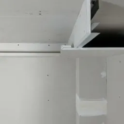 Montaż sufitu podwieszanego z płyt karton gips, widoczne profile i konstrukcja nośna, ściany w trakcie wykańczania, surowy stan.