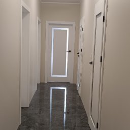 Berlin-Technik Łukasz Berliński - Korytarz z szarą marmurową podłogą i białymi drzwiami z czarnymi klamkami. Nowoczesne oświetlenie sufitowe. Perspektywa z głębi korytarza.