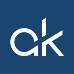 Białe litery 'ak' na ciemnoniebieskim tle, tworzące logo firmy.