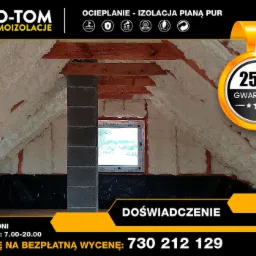 Poddasze ocieplone pianką PUR, widoczny komin z szarej cegły, okno dachowe i fragment reklamy firmy IZO-TOM z 25-letnią gwarancją.