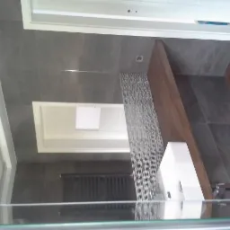 Nowoczesna łazienka w Janczewie z szarymi płytkami, drewnianym blatem i dekoracyjną mozaiką, widok z góry.