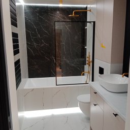 L.S Project - Nowoczesna łazienka z czarno-białymi marmurkowymi płytkami, złotą armaturą i podświetleniem LED