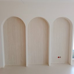 L.S Project - Wykończone wnęki w kształcie łuków, wyłożone okładziną imitującą drewno, widoczne gniazdka elektryczne, Elbląg.