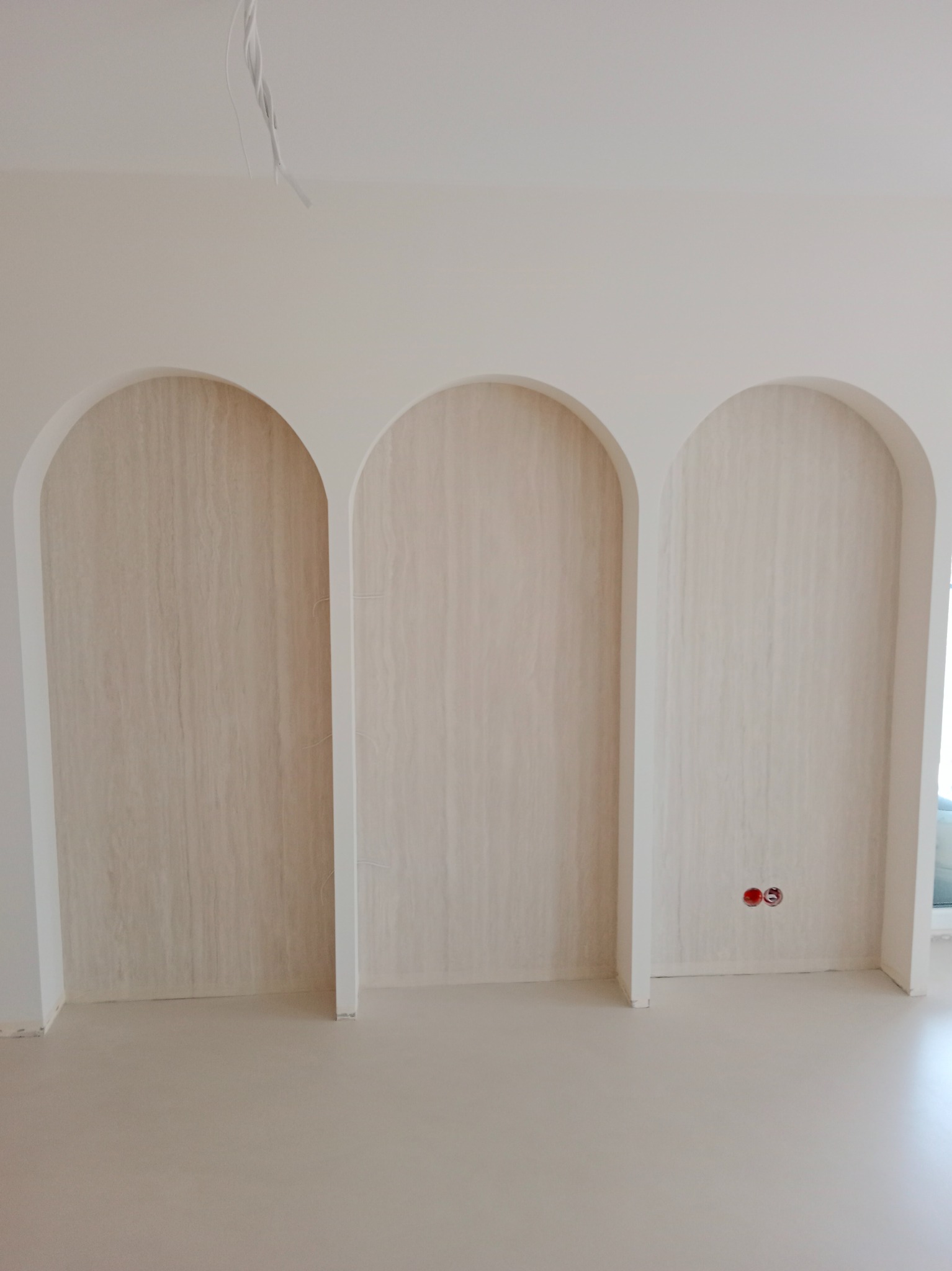 Wykończone wnęki w kształcie łuków, wyłożone okładziną imitującą drewno, widoczne gniazdka elektryczne, Elbląg.