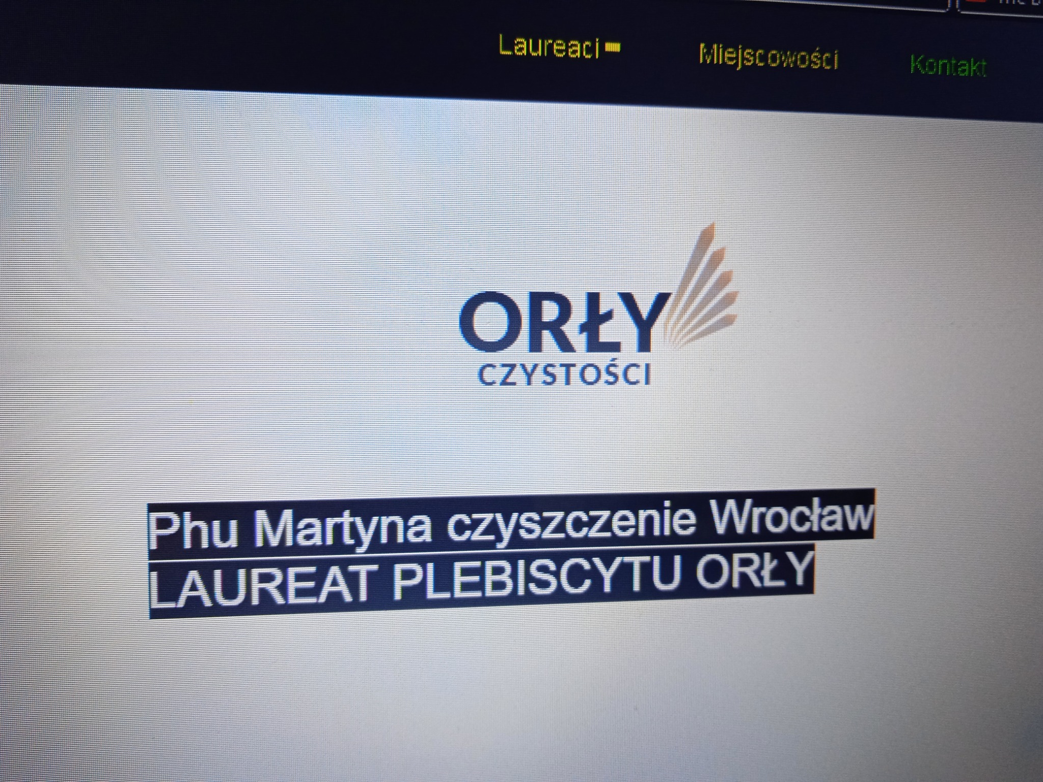 Ekran monitora prezentujący logo 'Orły Czystości' oraz informację o firmie 'Phu Martyna czyszczenie Wrocław' jako laureacie plebiscytu, z widocznymi zakładkami 'Laureaci', 'Miejscowości'...