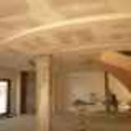 Wnętrze z antresolą w trakcie budowy, widoczne elementy konstrukcyjne i sufit z oświetleniem ledowym, częściowo rozmazane ujęcie.