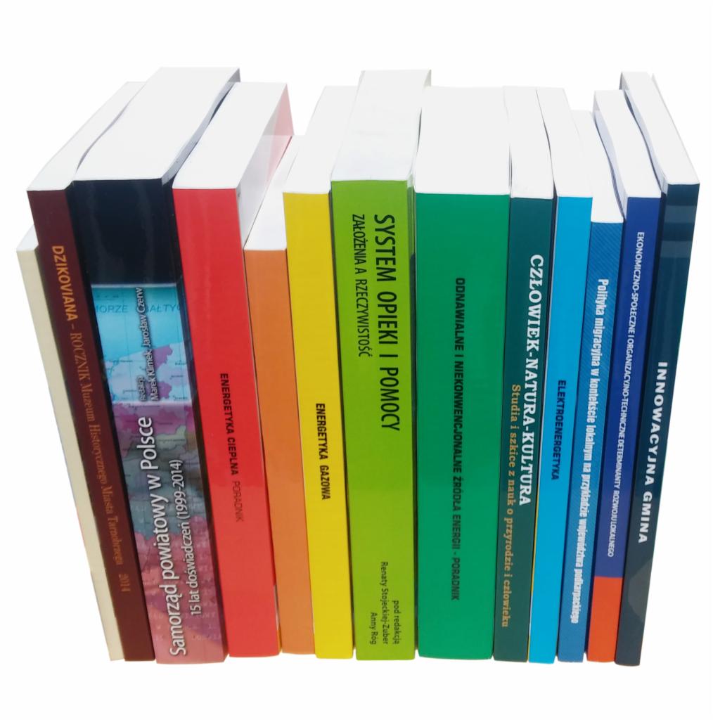 Rząd książek o różnej tematyce, w tym energetyce, samorządzie i kulturze, ustawionych obok siebie na białym tle, widoczne grzbiety z tytułami.