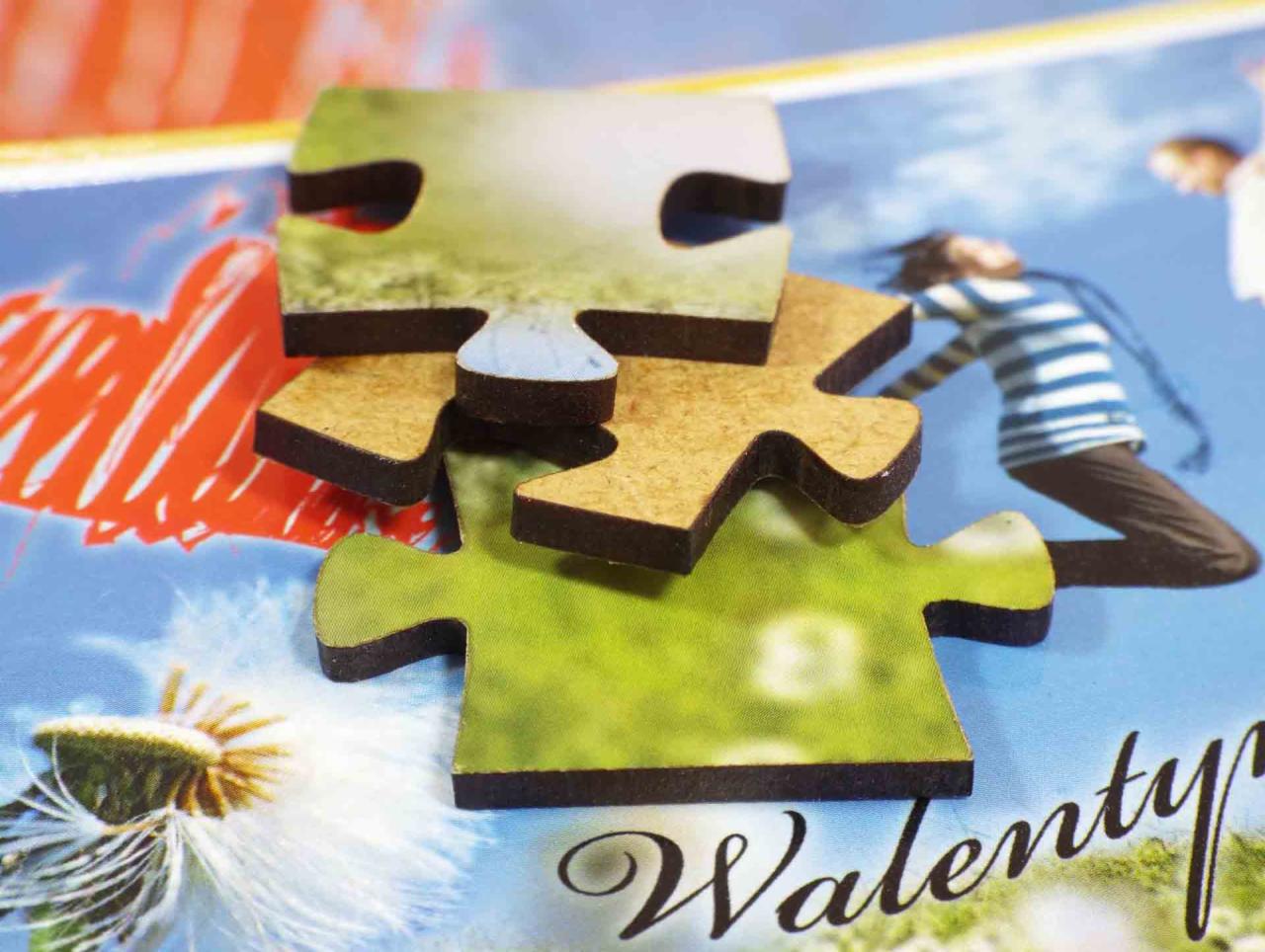 Niedopasowane elementy układanki z motywem walentynkowym, leżące na tle z nadrukiem, ukazującym postać skaczącej osoby, dmuchawca i czerwone serce.